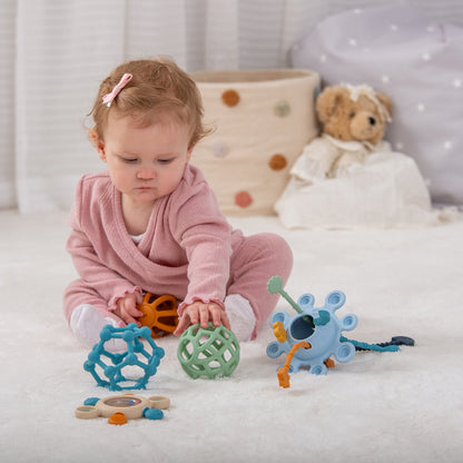 Baby playing with colorful sensory toys on soft rug, ideal for early development and tactile exploration