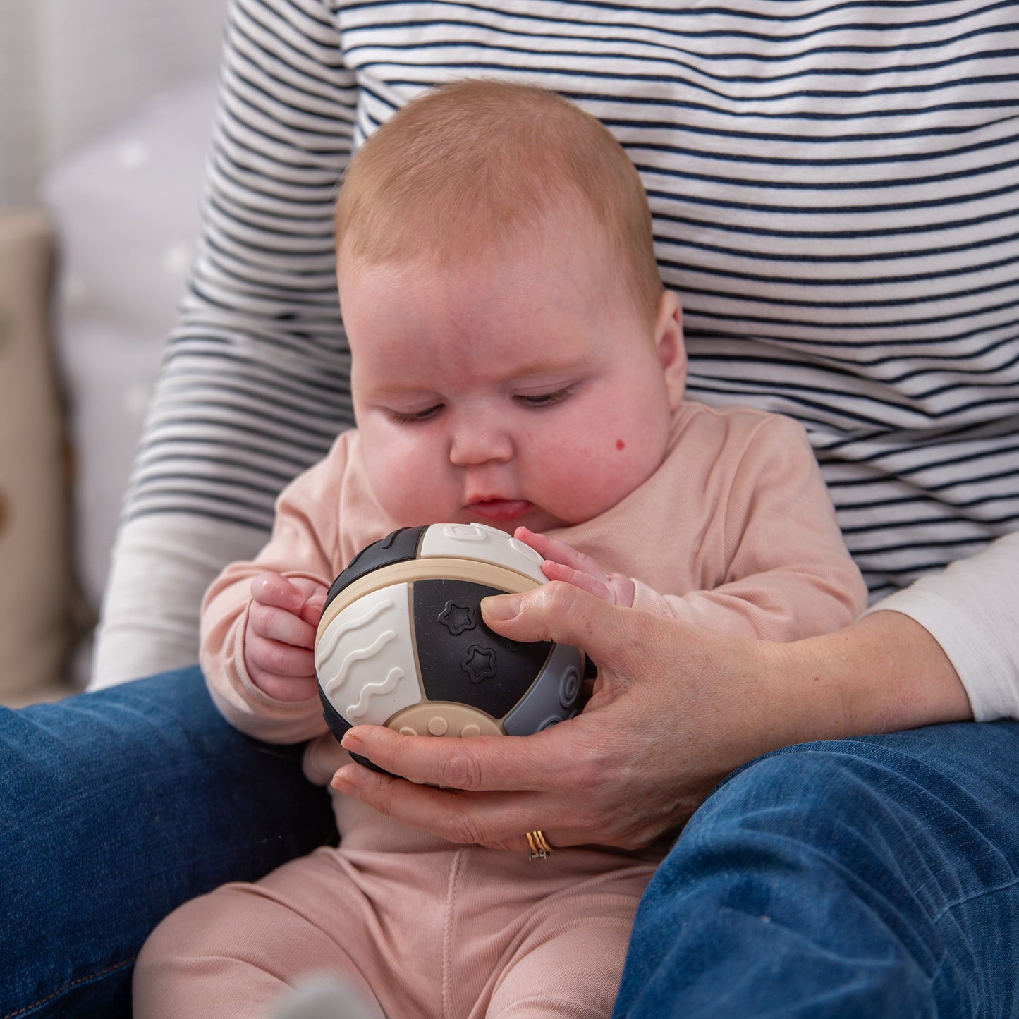 Baby playing with sensory development ball, tactile textures for infant exploration and motor skills