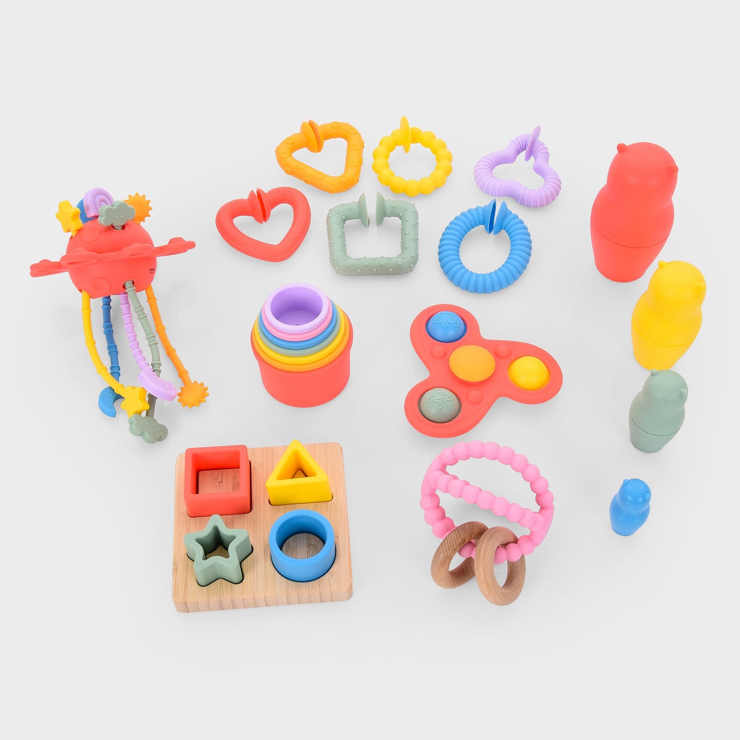 Colorful baby sensory toys including teething rings, shape sorter, stacking cups, and fidget spinner for infant development