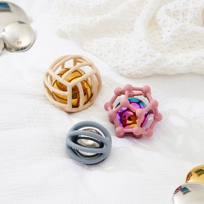 Colorful baby sensory balls with textured cages on soft white blanket, ideal for infant development and play