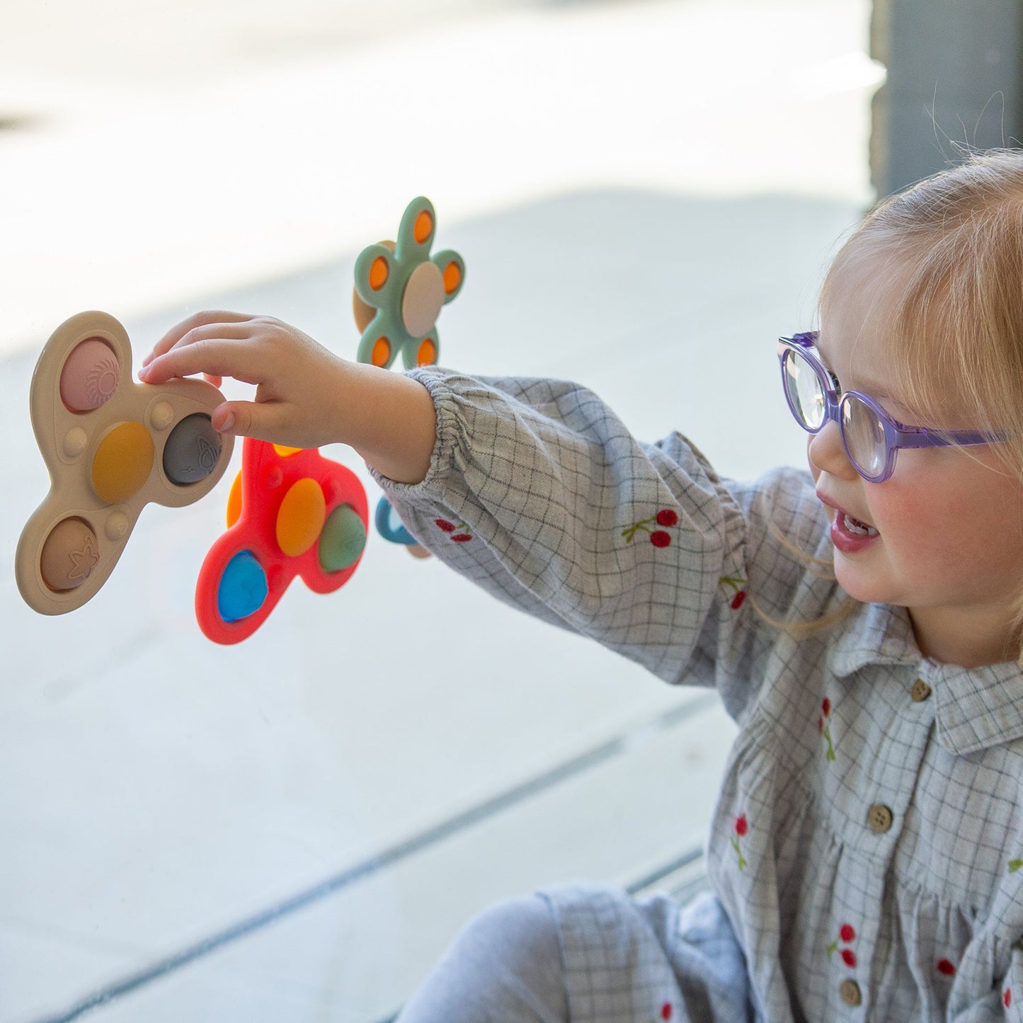 Child playing with colorful sensory toys, engaging in tactile learning activities.