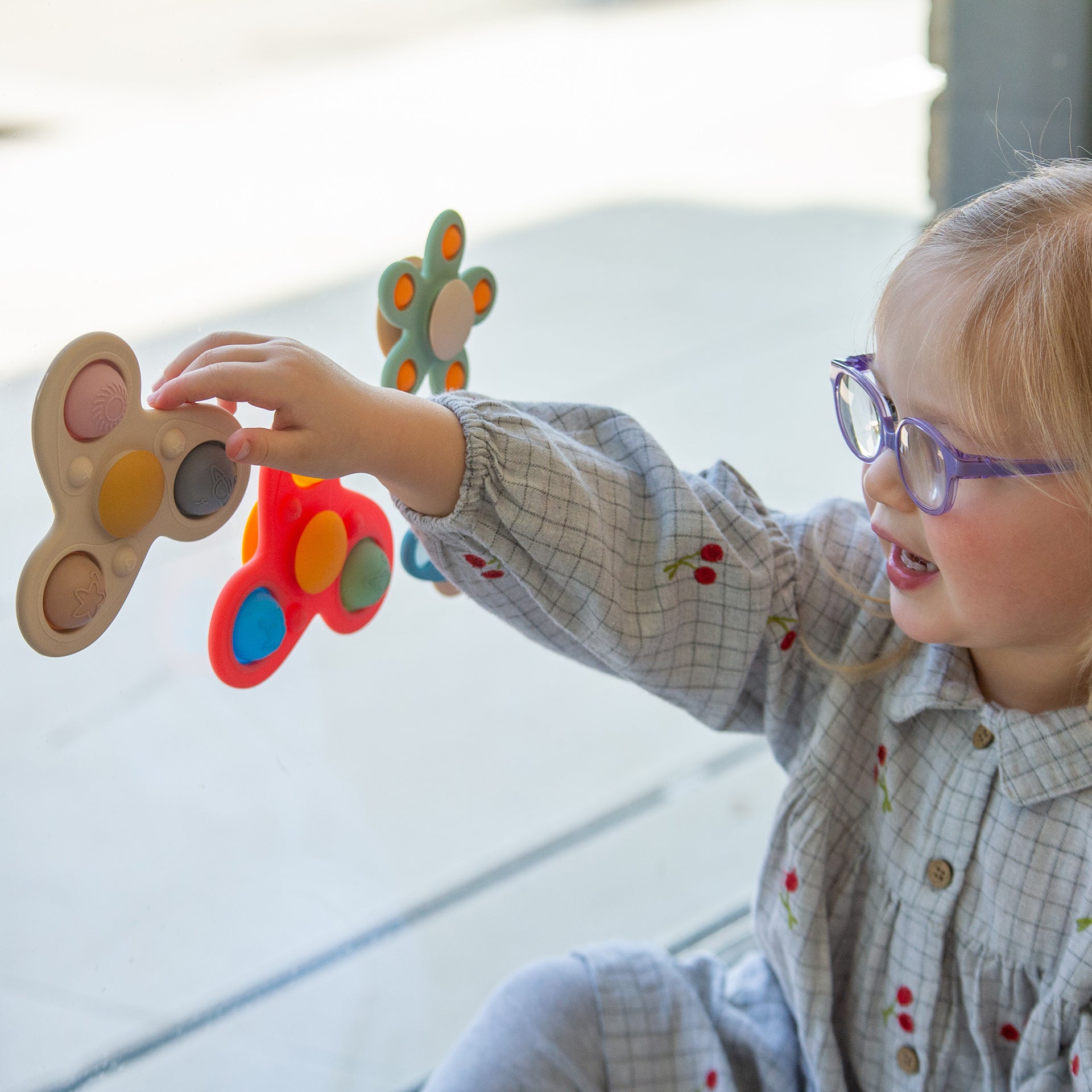 Child playing with colorful sensory toys, engaging in tactile learning activities.