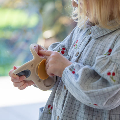 Child playing with sensory fidget toy, featuring colorful buttons and soft textures for tactile play.