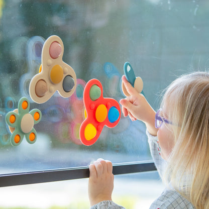 Child playing with colorful window cling toys, sensory fidget poppers for kids