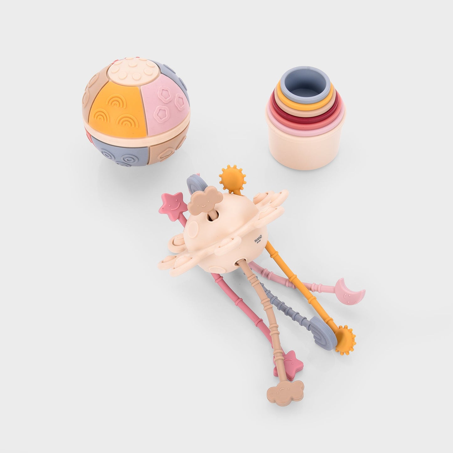 Colorful baby toys including sensory ball, stacking rings, and teether with stars and clouds