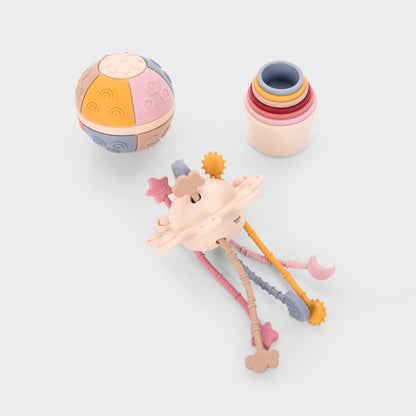 Colorful baby toys including sensory ball, stacking rings, and teether with stars and clouds