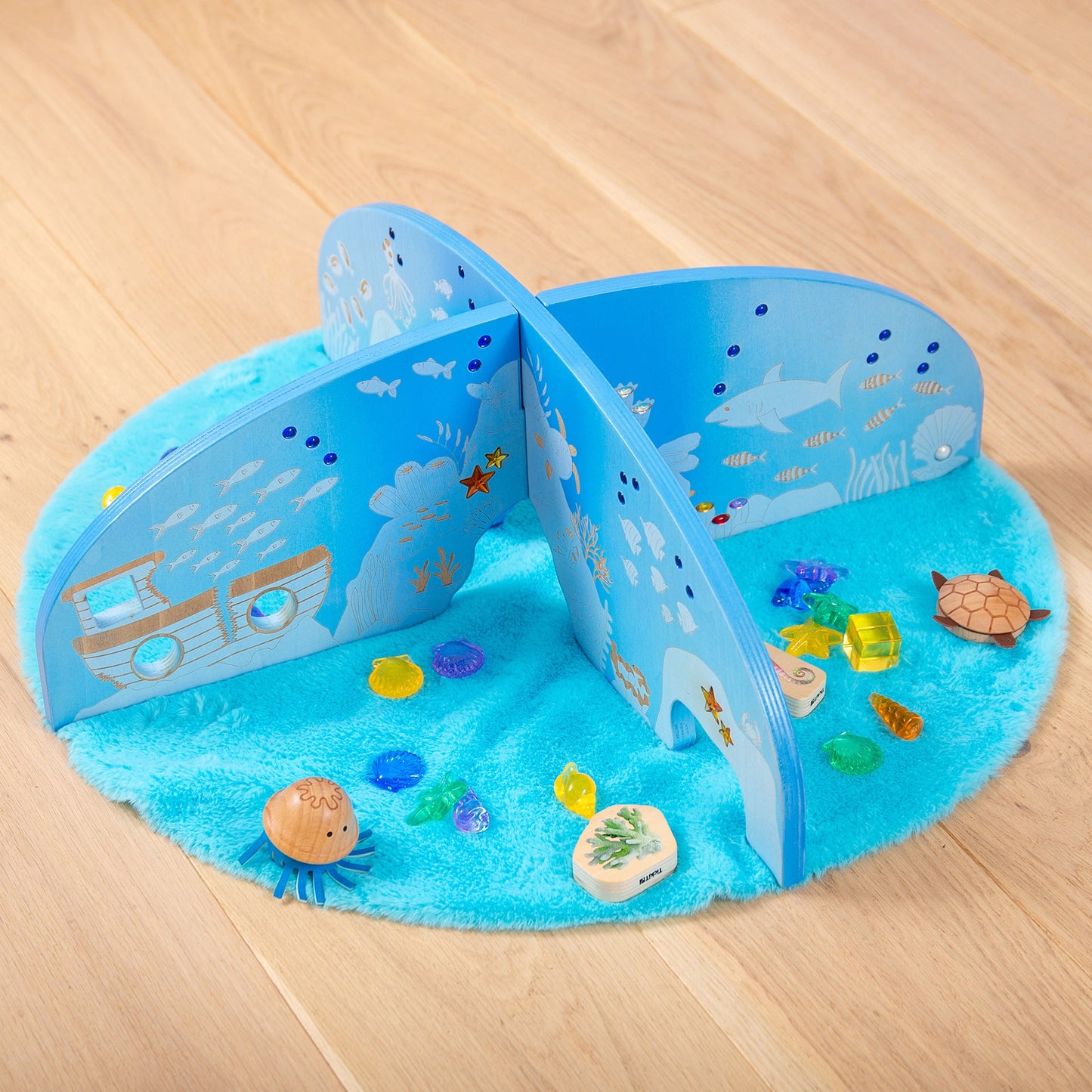 Underwater-themed wooden playset with ocean animals, coral, and sea creatures on blue felt mat