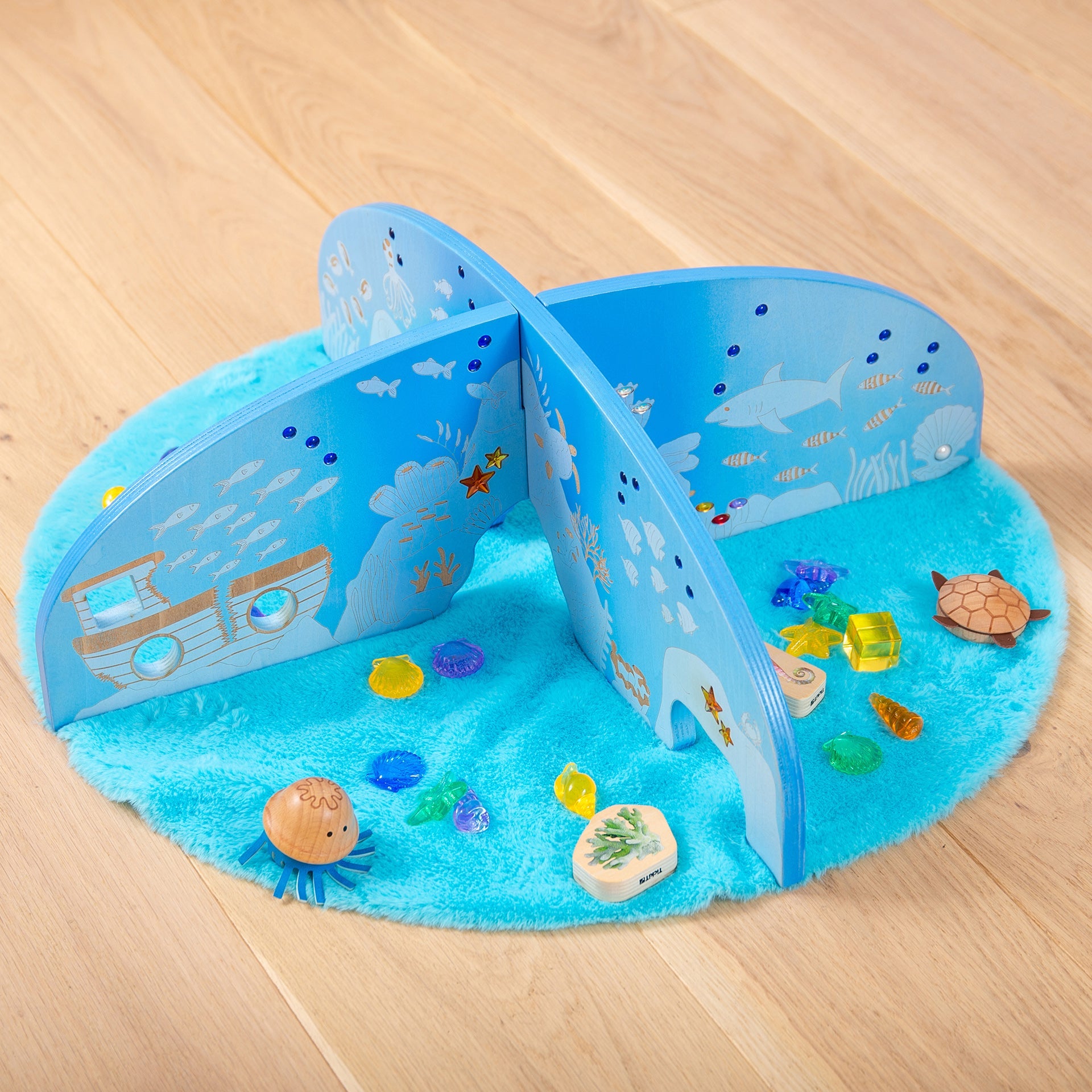 Underwater-themed wooden playset with ocean animals, coral, and sea creatures on blue felt mat